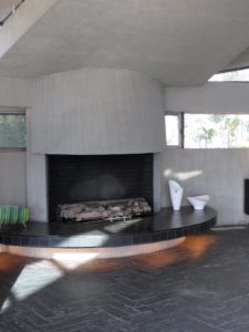A sleek fireplace in the living room, surrounded by zigzagging slate floor tiles