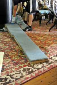 This is called a piano skid board - a must for moving pianos safely and efficiently. It's a solid piece of hardwood finished with a padded covering to help protect delicate piano surfaces.