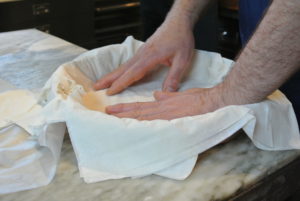 Phyllo is paper-thin sheets of dough used for baking pastries in Middle Eastern, Balkan, and Moroccan cuisine. Pierre carefully placed the first buttered sheets in the round pan, draping the excess over the edges.