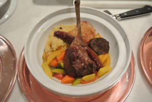 On each plate, Pierre placed a bed of couscous and topped it with perfectly roasted tender lamb chops and Merguez sausage, chicken, a small Moroccan hamburger and the vegetables.