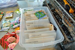 We keep seed packets in plastic envelopes, and plastic bins - all labeled and filed for easy reference. Mason jars with tight-fitting lids, or glass canisters with gasketed lids also work. Humidity and warmth shorten a seed’s shelf life, so we store all of the organized seed packets in a greenhouse refrigerator.