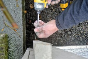 The same size screws are used to attach corner panels to wooden stakes, which will help to anchor the fence.