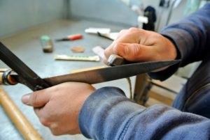 Once the sheers are completey clean, Wilmer uses a single edge blade to sharpen each side of the sheers. It doesn't need much - just about five or six strokes on each   edge.