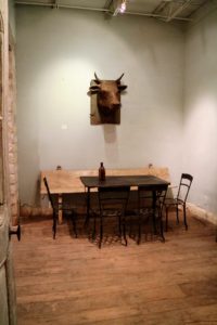 Here, an antique paper mache cow's head from the French Alps hangs on a lime washed wall. The  table is an antique Italian garden piece with a set of four antique iron chairs and a Spanish wooden bench, circa 1800 - all on a beautiful 18th century oak floor.