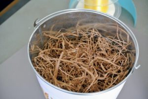 Easter grass comes in all different colors - we used natural light brown paper grass to fill these buckets.