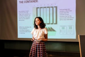 Tova explains how the produce is sourced from local farmers and markets, packaged into a special divided container based on longevity, and then delivered weekly by students. (Photo by Dana J. Quigley Photography)