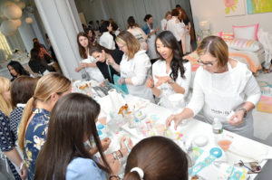 At this craft table, participants are busy stenciling and painting fabric pouches. I also made one for holding all my summer sunscreens. (Photo by Michael Loccisano/Getty Images for The Michaels Companies)