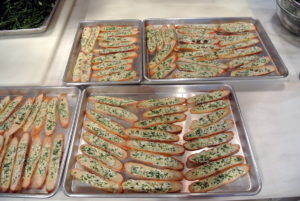Aron mixed an herb butter spread using greens from my vegetable greenhouse he cut earlier this day. He spread a generous amount onto each piece of bread and placed them in the oven.