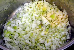 After adding the onions, add a couple cloves of garlic, sliced, into each pot.