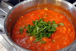 Next, add a bunch of chopped basil to each pot, and let it simmer for about an hour, uncovered. And don't forget to stir it occasionally. So easy!