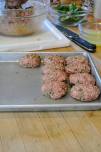 Ground lamb burgers are seasoned with salt, pepper, olive oil, spices and mint. All the meats are placed into the refrigerator until it is time to sear them and finish them off in the Winter House oven.