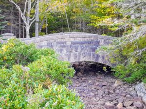 This is one of the 16 "Rockefeller Bridges" at Acadia. It is called Jordan Pond Bridge, also known as Jordan Pond Dam Bridge. Built in 1920, this bridge leads visitors from the Jordan Pond House out to the surrounding carriage roads.