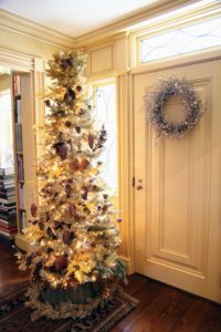 This tree sits on one end of the center hallway. It is a skinnier tree, but I love how it is dressed - overflowing with ornaments. If you look closely, we used tinsel at the bottom of the tree to surround the wicker tree skirt.