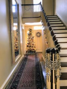 Guests entered the home to see the grand center stairway and handrail bedecked with a long garland of silver balls.