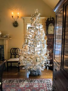 Here is another silver tinsel tree with silver pinecones and a silver tinsel garland draped on its branches.