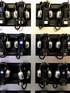 It can be very hard to hear what is happening at a race track with all of the horsepower thundering up into the stands. Here is a wall of headsets for those who want to get all the commentary and information on the race.