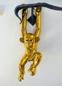 The is a brass monkey by Sergio. This whimsical yet detailed example hangs from the top railing of Lisbeth's staircase.