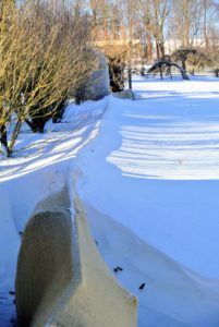 Nearby, my newly planted boxwood along the winding pergola is well-protected under burlap. The snow almost covers the entire row.
