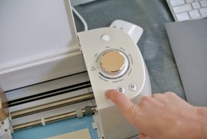 The button panel to the right is well labeled for each step of the cutting process. Shqipe presses the "on" button, then the "loading" button, and then "c" to start cutting.