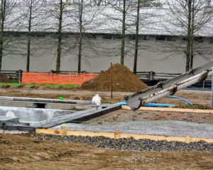 After the frame is complete, the concrete is poured for the base. The spout is first positioned in a corner of the pool and then guided lengthways to the opposite corner.