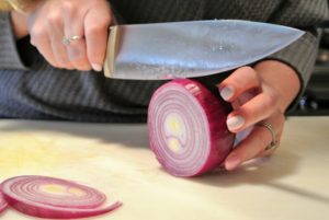 Next, the onion is peeled and sliced into half-inch thick rounds.