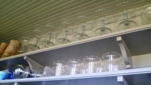 On higher shelves, Shqipe stored these large glass containers that aren't used too often, but are close by if needed.