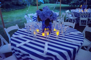 Votives illuminated each table as the sun went down. Steven styled each table perfectly with crisp blue and white linens and white chairs. (Photo by Daniel Gonzalez for Business of Home)