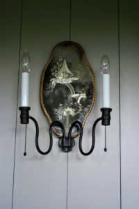 When electricity replaced the traditional candle sconce, many makers continued to top their pieces with specially designed, flame-shaped bulbs.