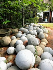 Leftover concrete is formed into giant spheres, which are rolled out into the woodland as relics.