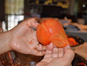 Enma takes each tomato and hand peels the skins - look how easy this is to do - boiling them really helps.