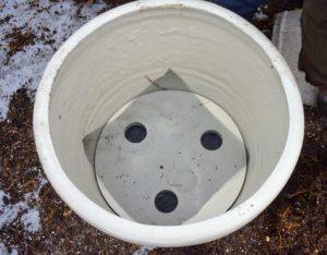 Here is one of the round planters with the "false bottom" inserted inside. We also placed a piece of mesh on top of the insert to prevent soil from falling through the drainage holes. All my pots are built with proper drainage holes.
