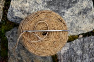 To sew the burlap, we use jute twine. It is all natural and the same color as the burlap. The needles are specially designed for sewing jute. These five-inch long needles have large eyes and bent tips. Every member of the outdoor grounds and gardening crews has his own needle.