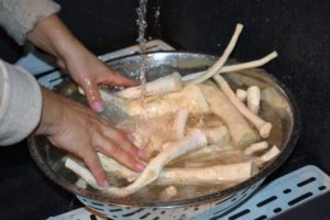 Working in batches, Enma then washes the horseradish to make sure the pieces are all free of any dirt.