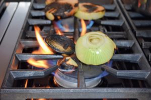 Inside the Flower Room kitchen, Chef Pierre charred onions straight on the flame - these onions add an intense smoky flavor to any dish.