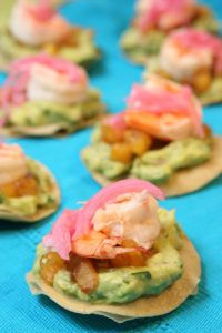 For a colorful one-bite, try Chef Sue Torres’ shrimp tostadas topped with cured red onions.