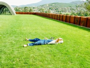 Here is one visitor taking advantage of the nature - resting on the real grass and under the summer sun. More Corten steel walls surround the lawn.