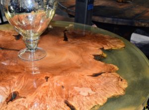 On this table, the top was made round by using epoxy to fill in and around the natural wood voids and edges.
