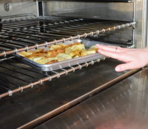 Two-tablespoons of olive oil are drizzled onto the wedges and then the baking sheet is placed into the hot oven until the fries are golden and crisp - about 25-minutes.