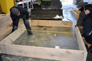 Phurba and Ryan measure the entire box before securing all the boards together. We calculated that we needed each box to measure six-feet by seven-feet, so that we could get 16-boxes into the greenhouse without compromising the necessary footpaths.