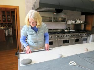 Gretchen measures a fresh piece of freezer paper to line the shelf. She also uses natural rocks to weigh it down. Gretchen is wearing my Quilted Down Short Sleeve Puffer Jacket in tide water blue - available from my collection on QVC.