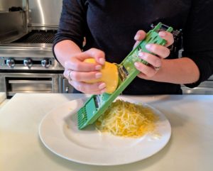 For this recipe, the first step is to prep the squash. The squash is grated using the largest holes on this grater, but a food processor with a shredding attachment also works.