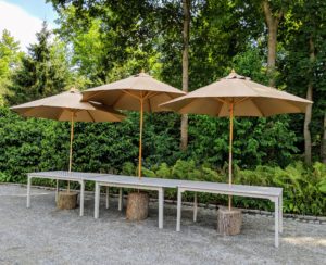 Here is the buffet area. I like to use heavy tree stumps for the umbrella bases - they are strong and made right here at the farm. The middle one is about six inches taller, so all three of the umbrellas can be positioned close together.