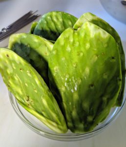Bright green cactus paddles are trimmed of any spines, thorns, and eyes and then washed.