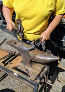 Linda also travels with a supply of horseshoes in a variety of sizes. Well-fitted shoes take a bit of time to create, but a good farrier will shape and reshape a shoe until it fits perfectly. Here, Linda uses the hammer to shape the shoe.