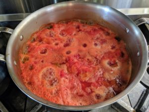Here's a batch of red tomatoes on the stove. Sanu adds just a bit of salt and pepper to taste.