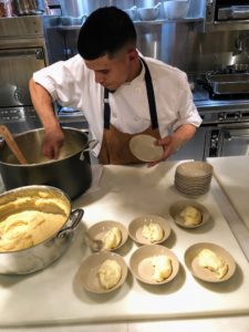 Back in the kitchen, Chef Pierre's sous chef, Moises, plates mashed potatoes and mashed parsnips as a side dish.