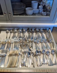 All the necessary silver utensils are pulled from the drawer and added to the table settings.
