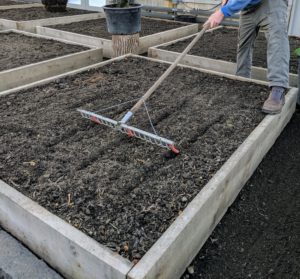 Ryan uses this bed preparation rake from Johnny’s Selected Seeds to create furrows in the soil. Hard plastic red tubes slide onto selected teeth of the rake to mark the rows.