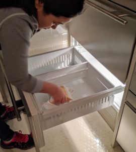 I have a spare refrigerator in the basement of the Tenant House. It's always a good idea to go through any fridge regularly. Here, Sanu emptied the freezer bins and wiped the drawers with a damp cloth.