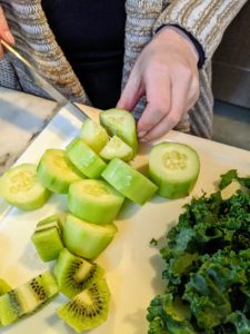 We always send the freshest ingredients possible. Here, Shqipe cuts the cucumber into smaller chunk pieces.